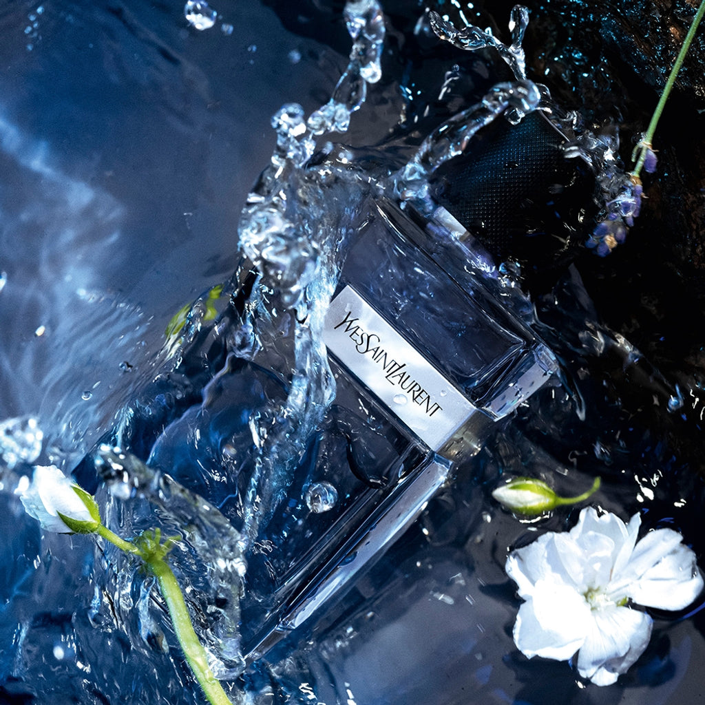YSL perfume bottle with water splash and flowers on a dark backgroundYves Saint Laurent Y Eau de Toilette 100 ml for Men With Fresh Woody Masculine Fragrance