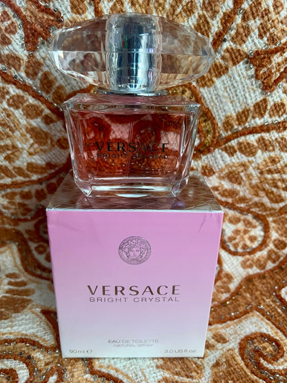 Versace perfume bottle and packaging on a patterned surface