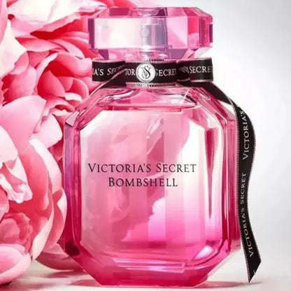 Pink Victoria's Secret Bombshell perfume bottle with floral background