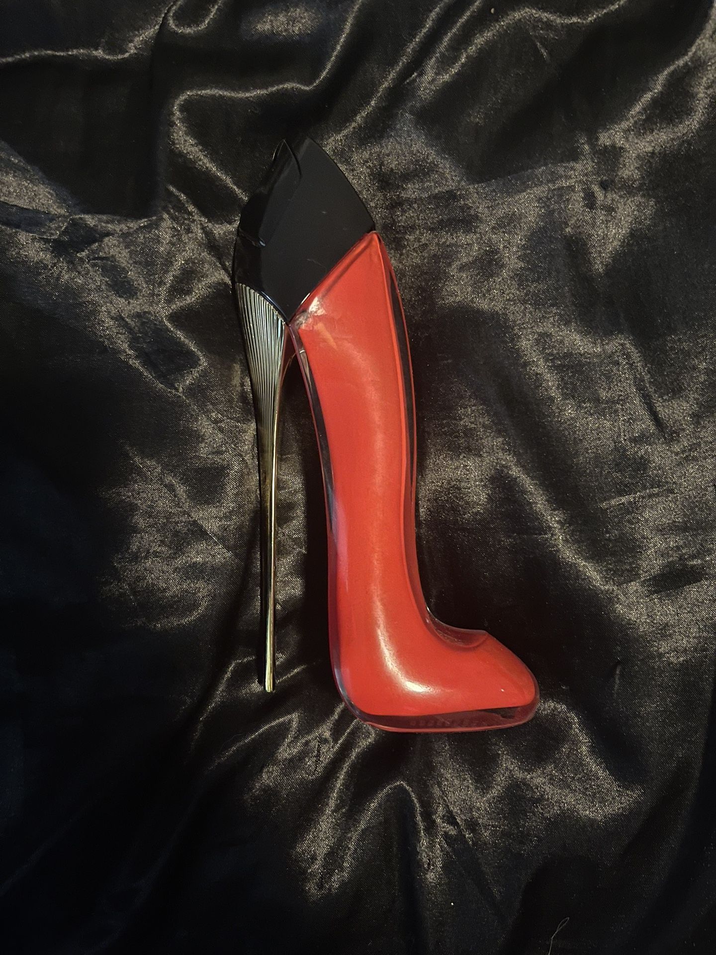 Red high-heeled shoe on a black textured surface