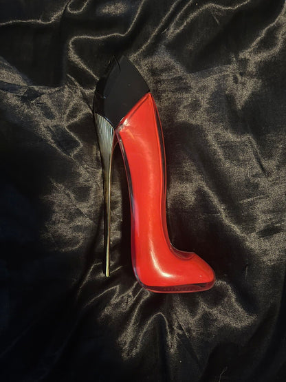 Red high-heeled shoe on a black textured surface