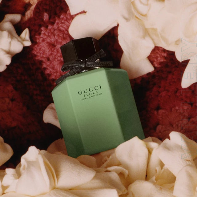 Green Gucci perfume bottle with a black bow on a floral background Green Gucci perfume bottle and packaging with floral design on a neutral background Gucci Flora Emerald Gardenia 100ml