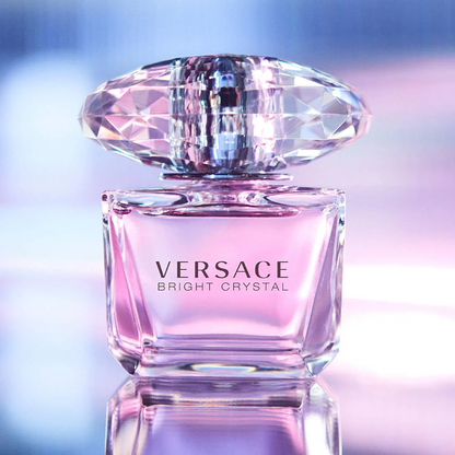 Versace Bright Crystal perfume bottle with a diamond-shaped cap on a reflective surface.