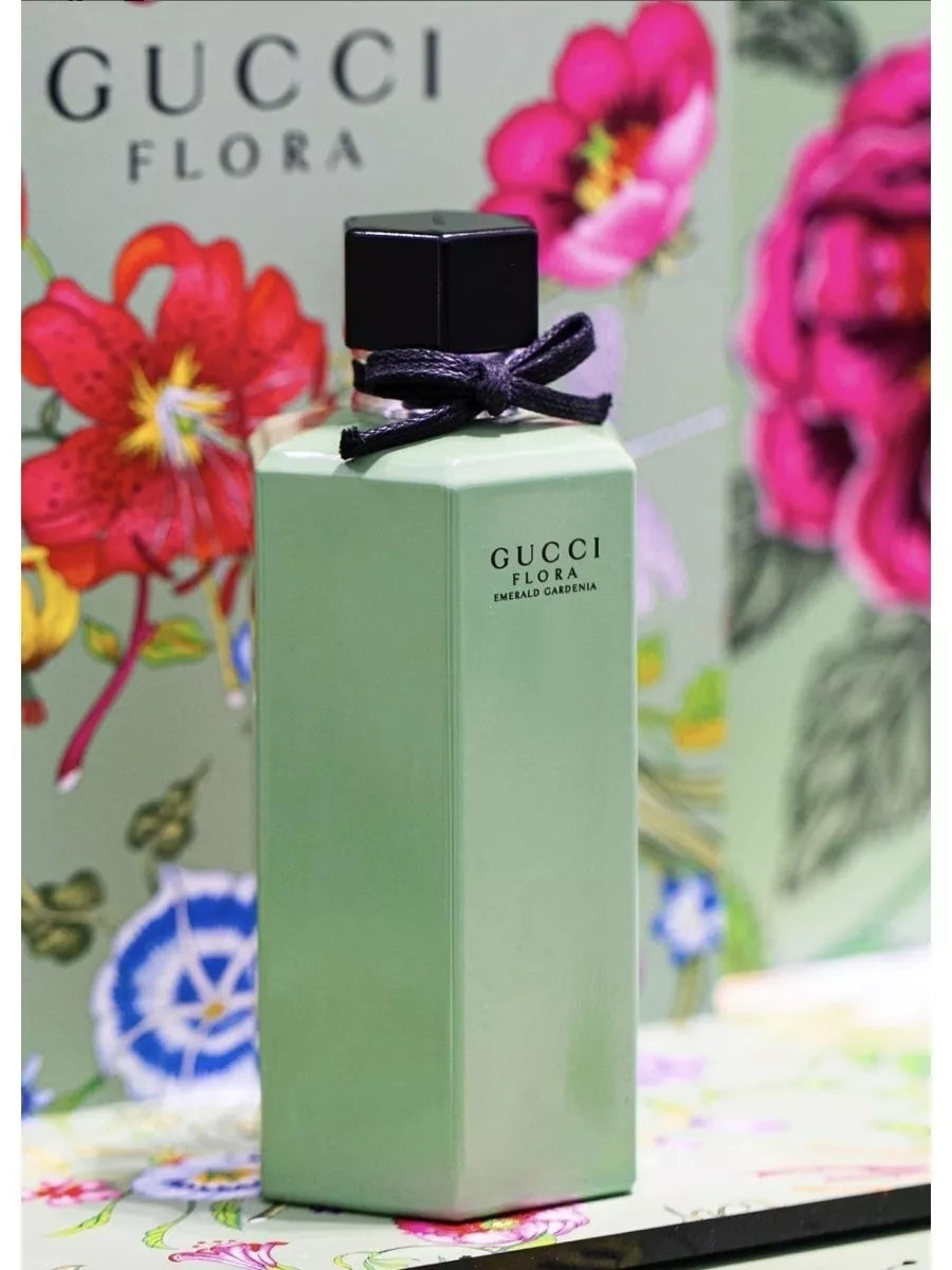 Green Gucci perfume bottle and packaging with floral design on a neutral background Gucci Flora Emerald Gardenia 100ml