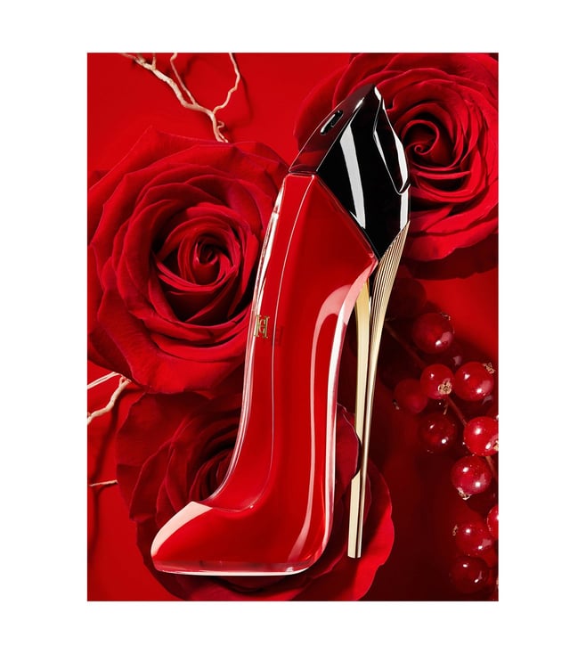 Red high-heeled shoe with gold accents on a red rose and berry background