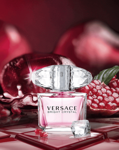 Versace Bright Crystal perfume bottle with pomegranate fruits on a red background
