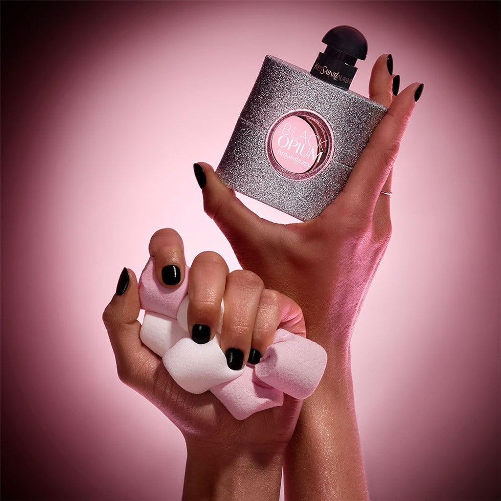 Hand holding a silver and pink OPI nail polish bottle against a pink background