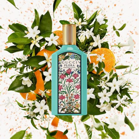 Gucci Flora perfume bottle  surrounded by flowers and oranges on a decorative backgroundGucci Flora Gorgeous Jasmine Eau de Parfum 100 ml (3.4 fl.oz)