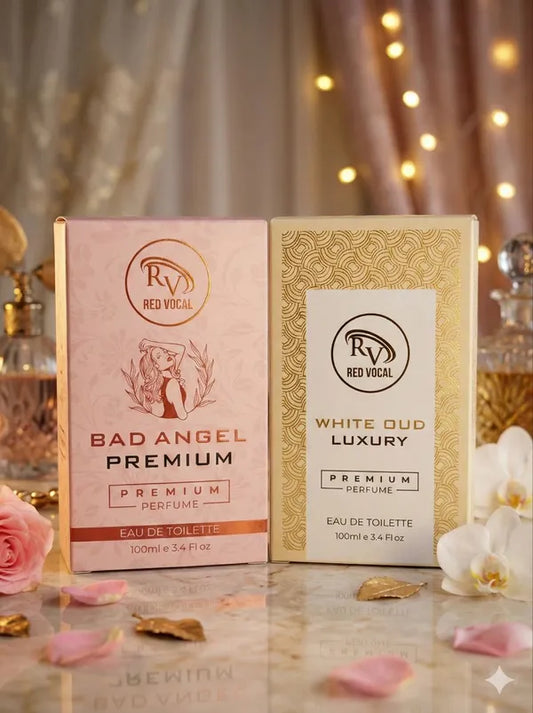Two perfume boxes from Red Vocal on a decorative surface with flowers and lights in the background. Buy Red Vocal Bad Angel &amp; White Oud perfume combo 2x100ml. Seductive women’s scent and luxury unisex oud EDT. Long-lasting, 100% original.