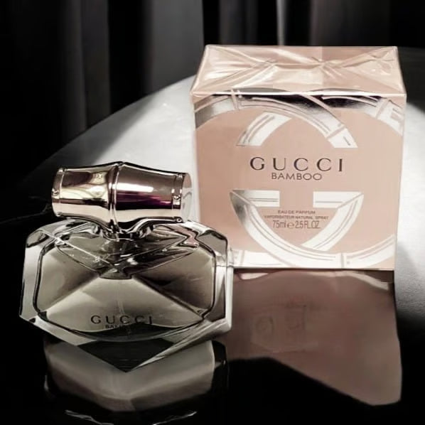 Gucci Bamboo perfume bottle and packaging on a reflective surface with a dark background Discover Gucci Bamboo EDP 75ml at AVS Fragrances. Gucci Bamboo Eau de Parfum 75 ml (2.5 fl.oz)