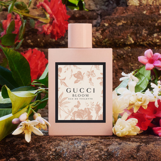 Gucci Bloom perfume bottle surrounded by flowers on a stone Gucci Bloom Eau de Parfum 100 ml (3.4 fl.oz)surface